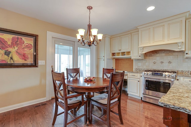 dining room with a notable chandelier and light wood-type flooring