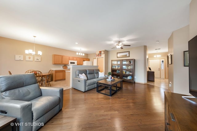 living room featuring wood-type flooring and ceiling fan with notable chandelier