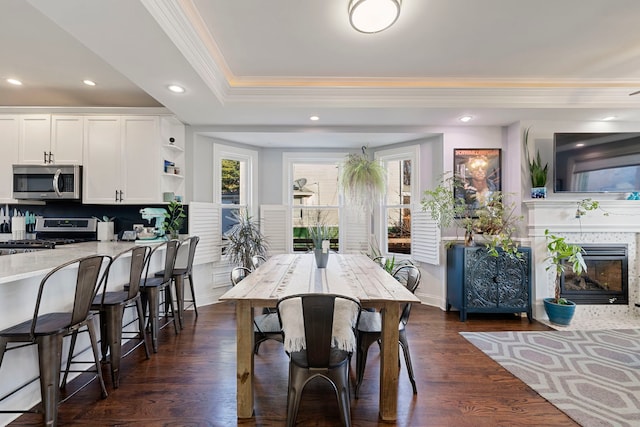 dining room featuring dark hardwood / wood-style flooring, crown molding, and a raised ceiling