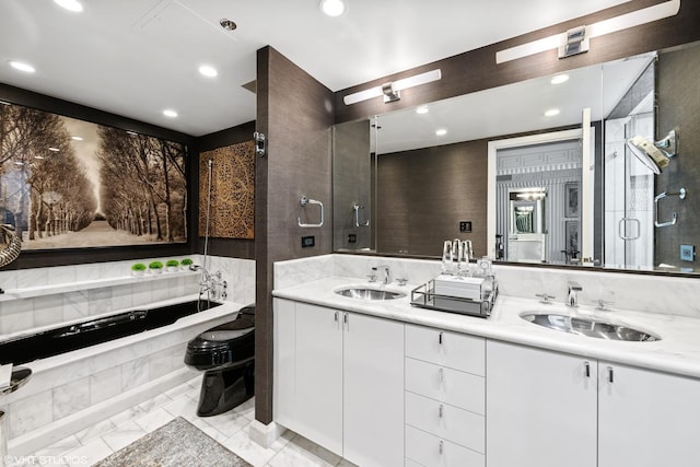 bathroom featuring a relaxing tiled tub and vanity