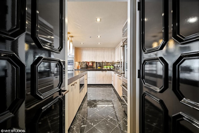 kitchen with stainless steel oven, light brown cabinetry, black oven, and backsplash