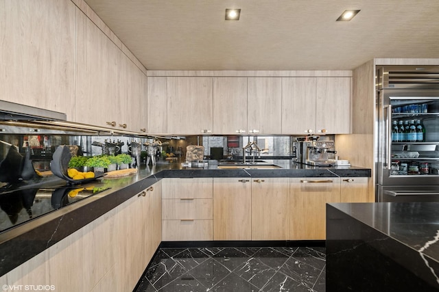 kitchen featuring fridge, black electric stovetop, and light brown cabinets