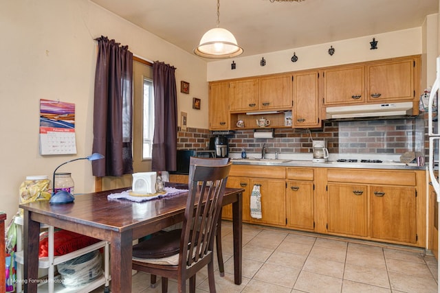 kitchen featuring tasteful backsplash, hanging light fixtures, light tile patterned floors, and sink