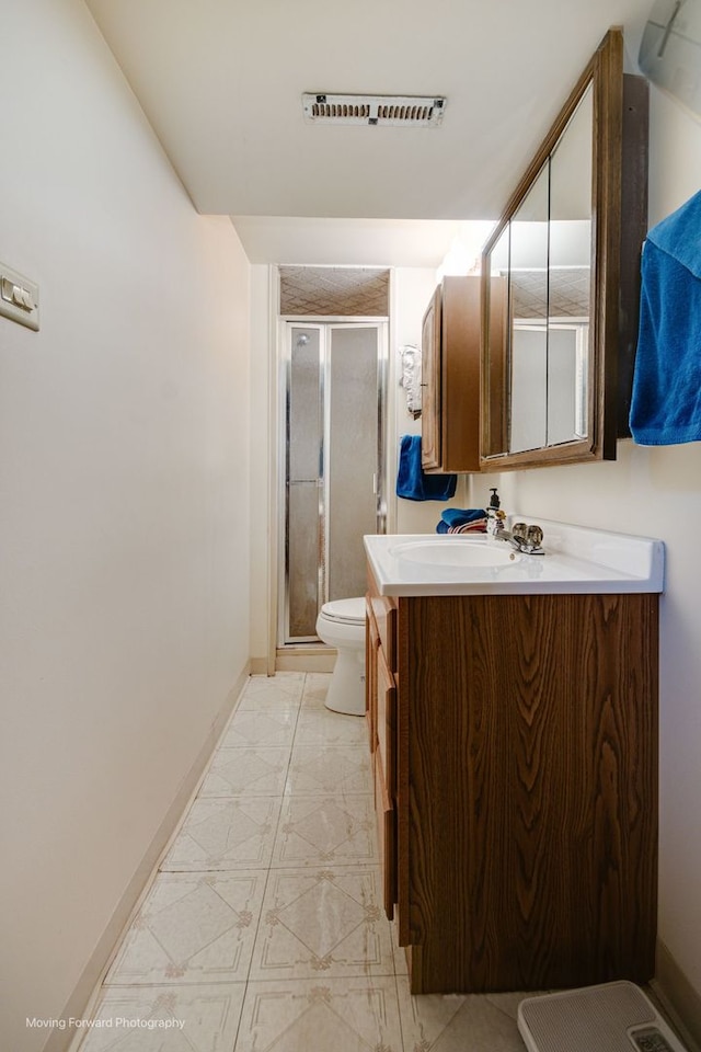 bathroom with vanity, an enclosed shower, and toilet