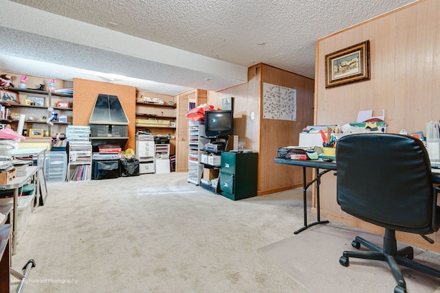 carpeted office space with a textured ceiling and wood walls