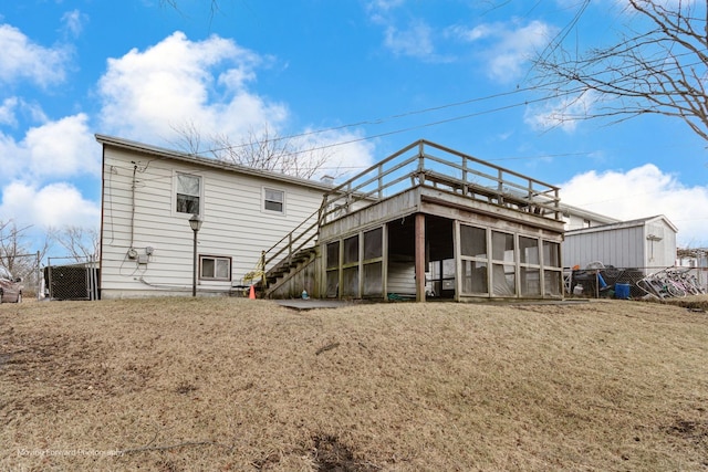 back of house featuring a sunroom and a lawn