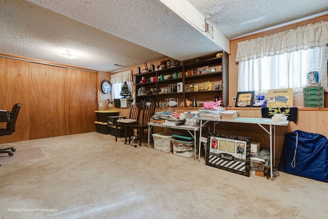 office with carpet flooring, a textured ceiling, and wood walls