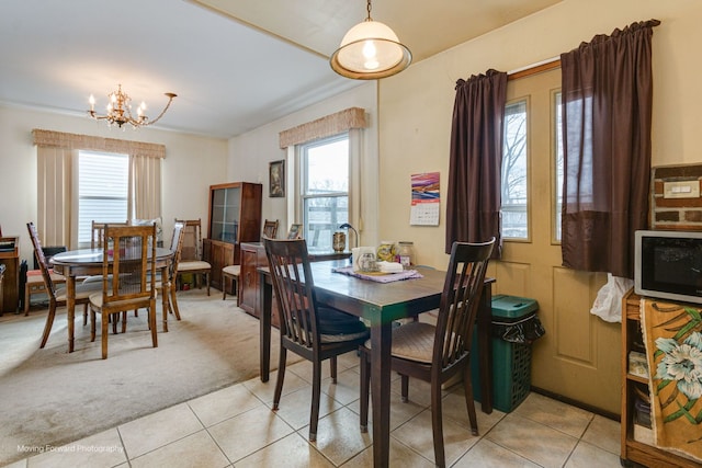 carpeted dining area featuring a chandelier