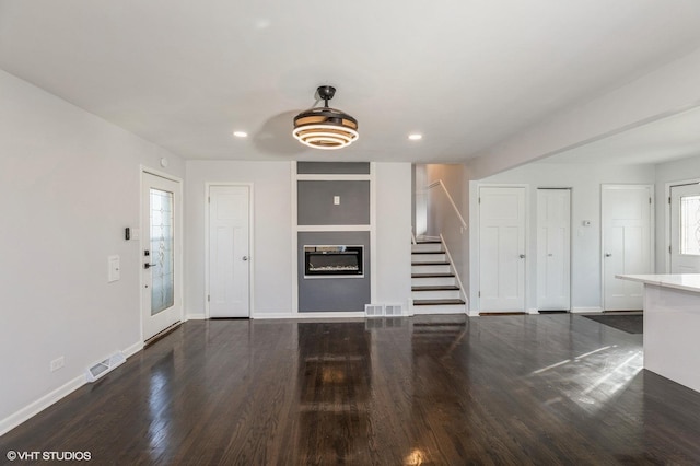 unfurnished living room with dark hardwood / wood-style flooring