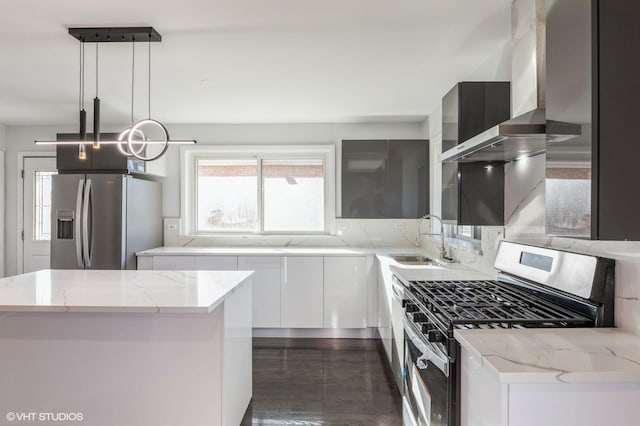 kitchen with pendant lighting, sink, appliances with stainless steel finishes, white cabinetry, and a center island