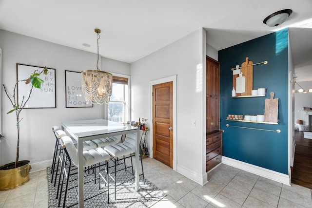 dining room with tile patterned floors and a chandelier