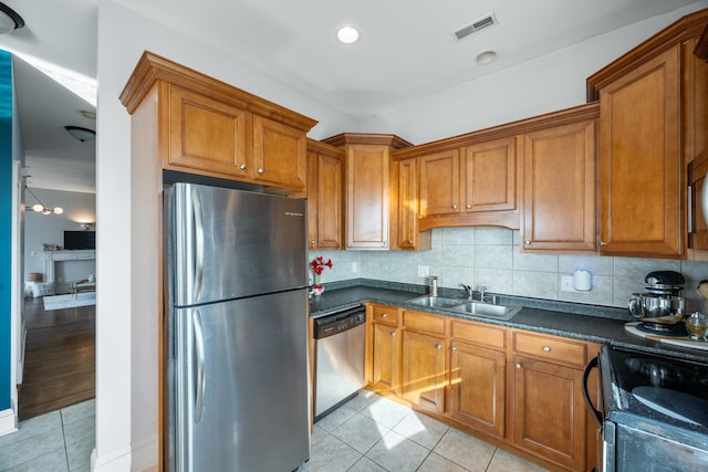 kitchen with light tile patterned flooring, stainless steel appliances, sink, and backsplash