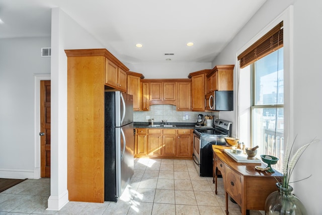 kitchen with sink, decorative backsplash, stainless steel appliances, and light tile patterned flooring