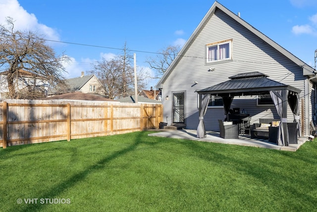 rear view of house with a gazebo, a patio area, and a lawn