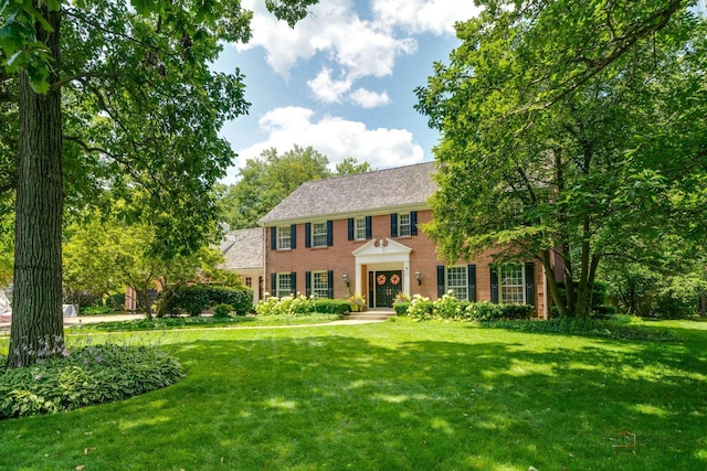 colonial-style house featuring a front yard