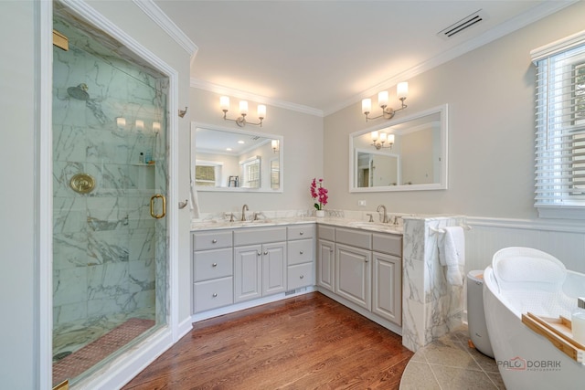 bathroom featuring walk in shower, ornamental molding, hardwood / wood-style floors, and vanity