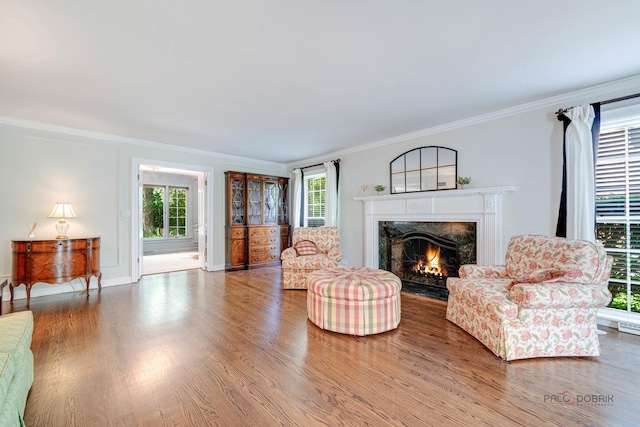 living room with hardwood / wood-style flooring, ornamental molding, and a premium fireplace