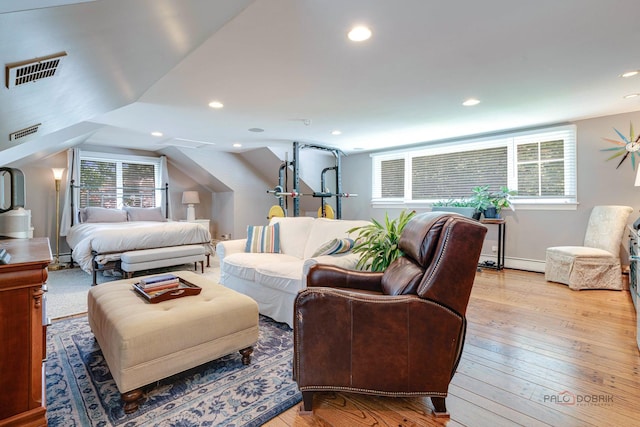 bedroom featuring lofted ceiling, light hardwood / wood-style floors, and baseboard heating