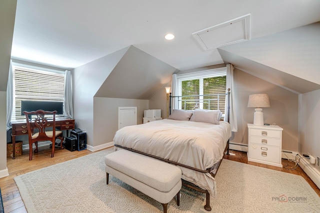 bedroom with lofted ceiling, light hardwood / wood-style flooring, and a baseboard heating unit