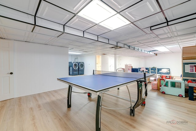 recreation room with washing machine and clothes dryer and light wood-type flooring