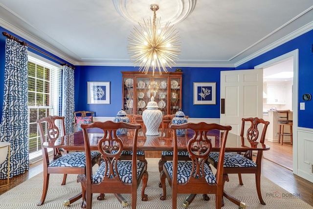 dining space with an inviting chandelier, crown molding, and hardwood / wood-style flooring