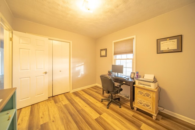 office area featuring light hardwood / wood-style flooring and a textured ceiling