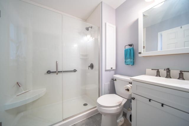 bathroom with vanity, tile patterned flooring, a shower with door, and toilet