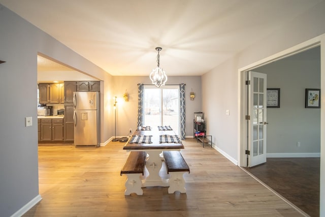 dining area with an inviting chandelier and light wood-type flooring