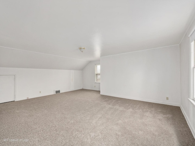 bonus room featuring lofted ceiling and carpet floors