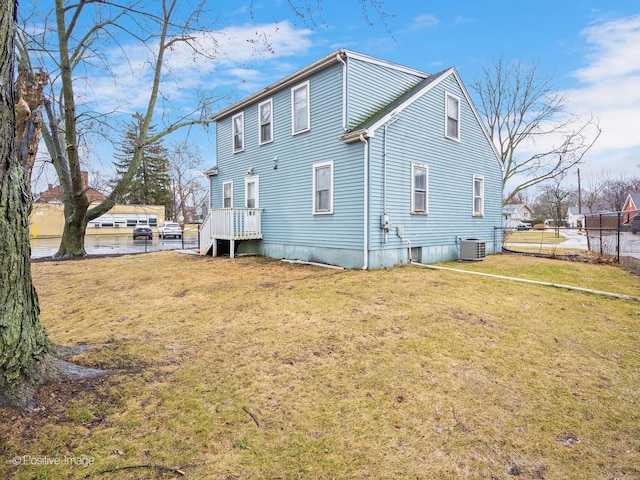 rear view of house featuring a yard and central air condition unit