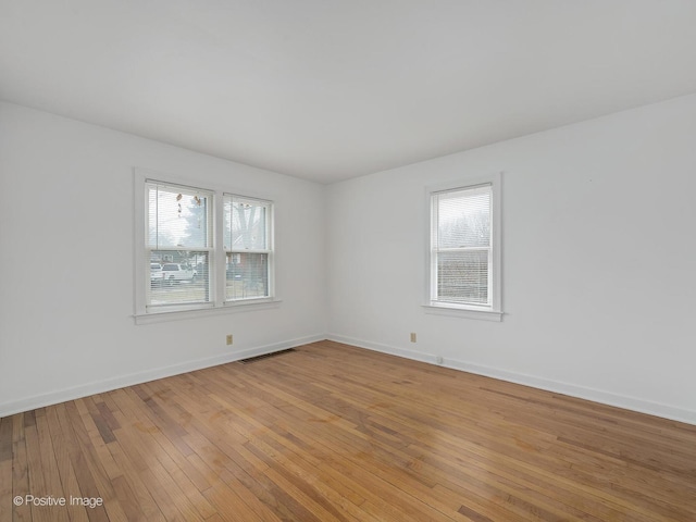 empty room featuring plenty of natural light and light hardwood / wood-style floors