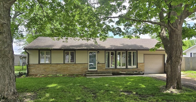 ranch-style house featuring a garage and a front lawn