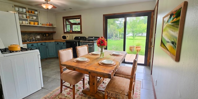 dining space featuring sink, ceiling fan, and light tile patterned flooring