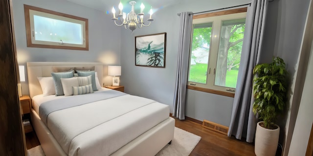 bedroom featuring a notable chandelier and dark hardwood / wood-style flooring