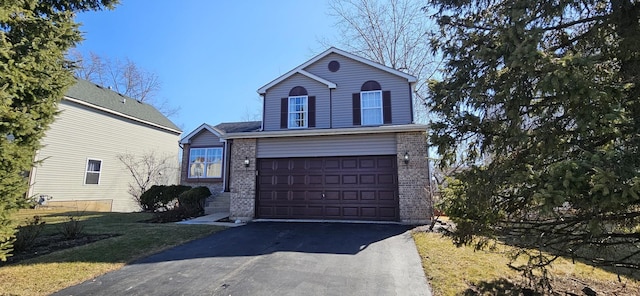 view of front of home with a garage, brick siding, and driveway