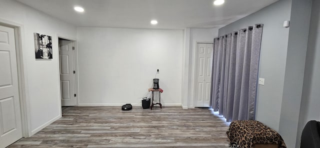 workout area featuring recessed lighting, baseboards, and wood finished floors