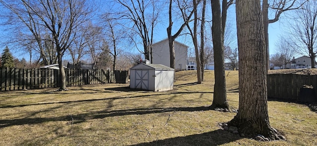 view of yard featuring an outbuilding, a fenced backyard, and a shed