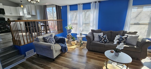 living area featuring a wealth of natural light, visible vents, and wood finished floors