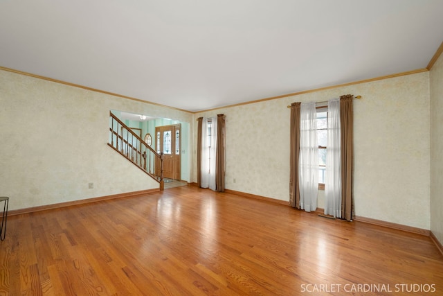 empty room featuring ornamental molding and light hardwood / wood-style floors