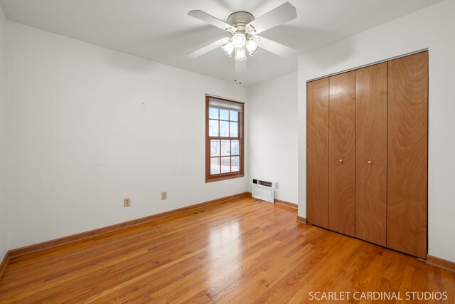 unfurnished bedroom with ceiling fan, light wood-type flooring, and a closet