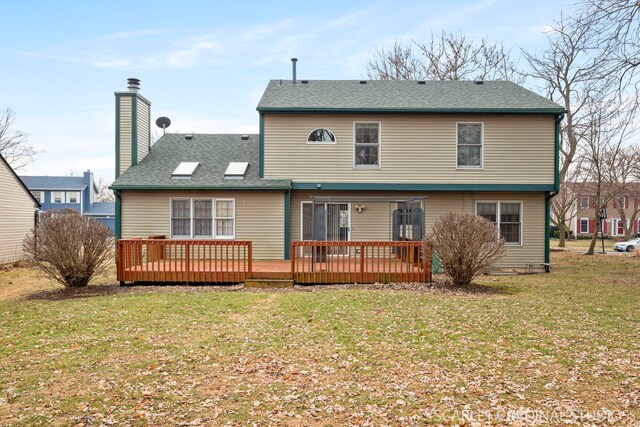 back of house featuring a wooden deck and a yard