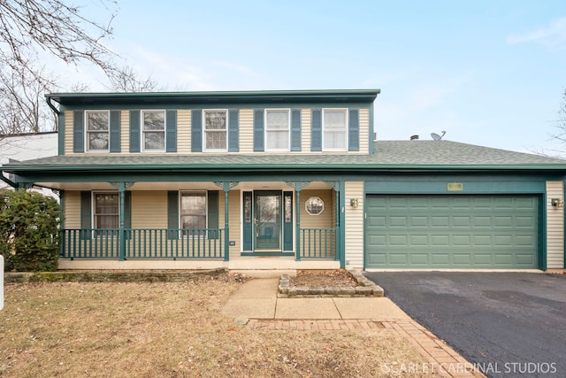 front of property featuring a porch, a garage, and a front lawn