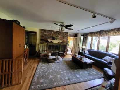 living room featuring hardwood / wood-style flooring, ceiling fan, and a fireplace