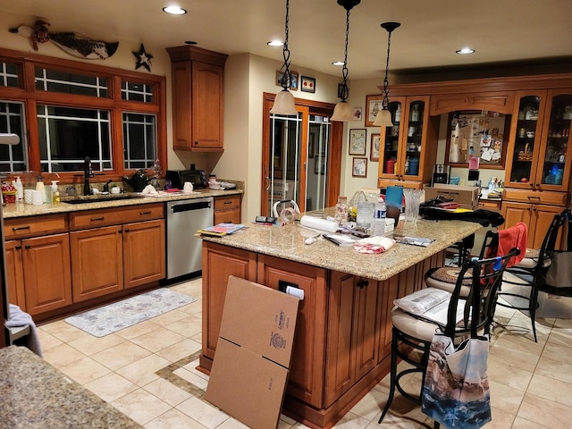 kitchen with a kitchen island, dishwasher, sink, a kitchen bar, and hanging light fixtures