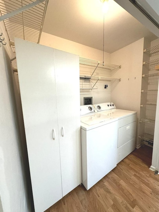 washroom with washing machine and dryer and hardwood / wood-style floors