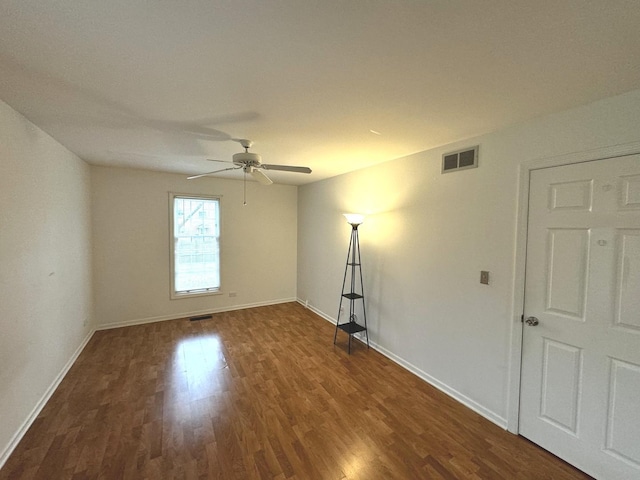 spare room with dark hardwood / wood-style floors and ceiling fan