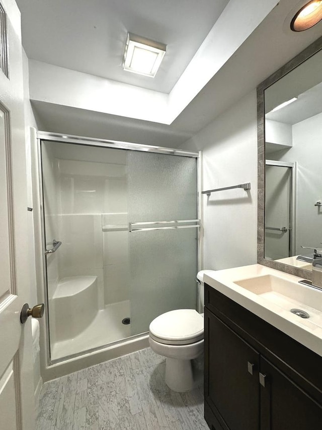 bathroom featuring vanity, hardwood / wood-style floors, toilet, and walk in shower