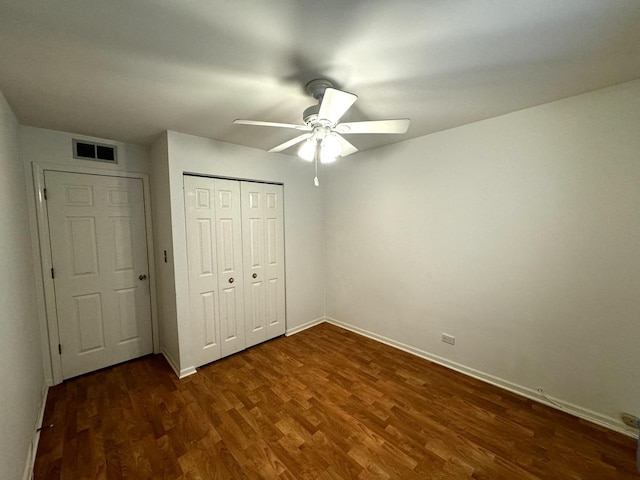 unfurnished bedroom with a closet, dark hardwood / wood-style floors, and ceiling fan