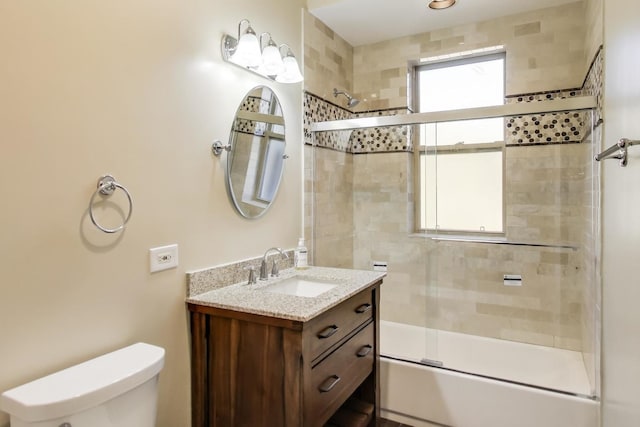 full bathroom with vanity, shower / bath combination with glass door, and toilet