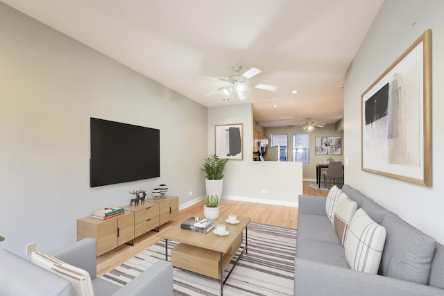 living room featuring hardwood / wood-style floors and ceiling fan